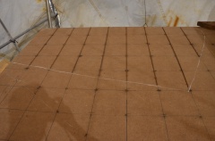 Rebar is placed in one direction on grids within traced shape of mold